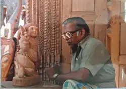 Appukuttan at work with traditional wooden sculpture in 1982