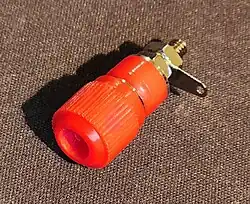 A binding post, colored red, which usually indicates a positive terminal.