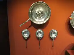 Shallow bowl above three silver spoons