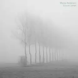 A photograph of a row of dead trees, obscured by a dense fog.