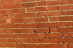 Defective pointing can allow rain to penetrate through masonry walls.