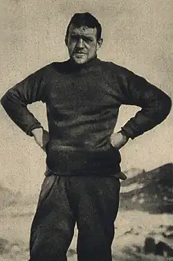 Dark-haired man, hands on hips, looking straight at the camera