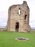 The castle well and a corner tower with some of its original ashlar cladding.