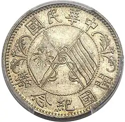 A silver coin with two crossed flags surrounded by Chinese text