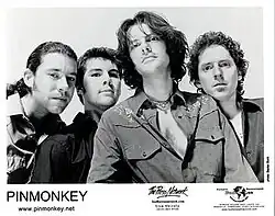 A black-and-white promotional photo of the band Pinmonkey, showing all four members