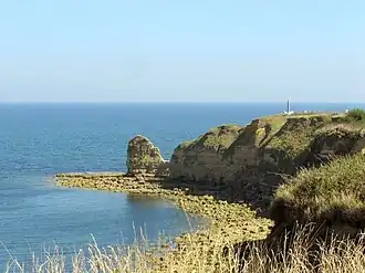 Present day view of the cliff of Pointe du Hoc with the monument on the top-right.