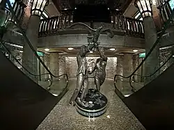 Wide view showing the Diana and Dodi statue positioned against elaborate Egyptian-style carved decorations and hieroglyphic motifs