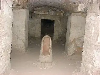 View of burial chamber, showing trace paint on opposing lintel, and urn.