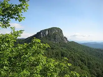A huge rock on top of a mountain with a flat top